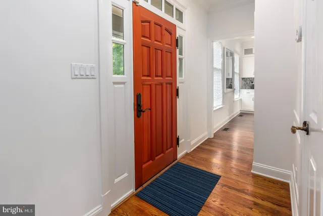 a view of a hallway with wooden floor and staircase