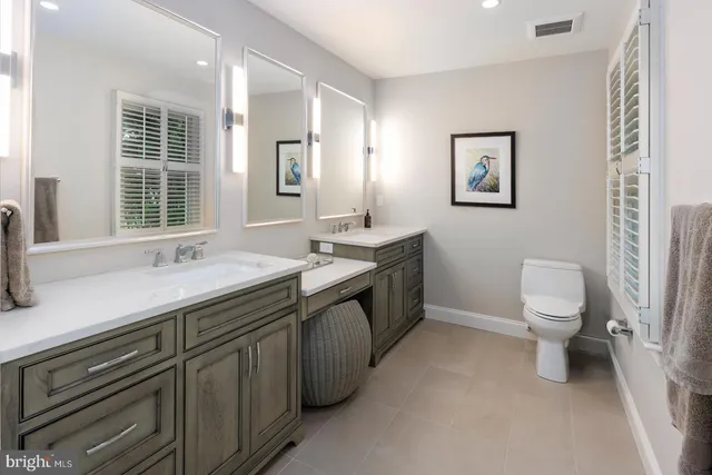 a spacious bathroom with a double vanity sink toilet and a tub