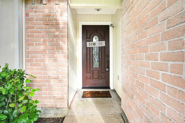 a view of entrance door of a house with potted plants