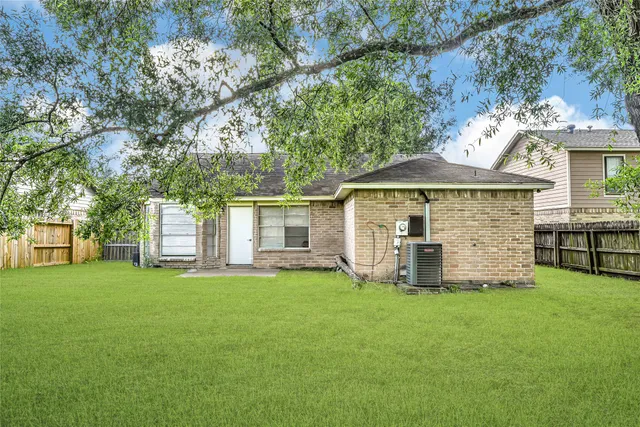 a view of a house with a yard and large trees