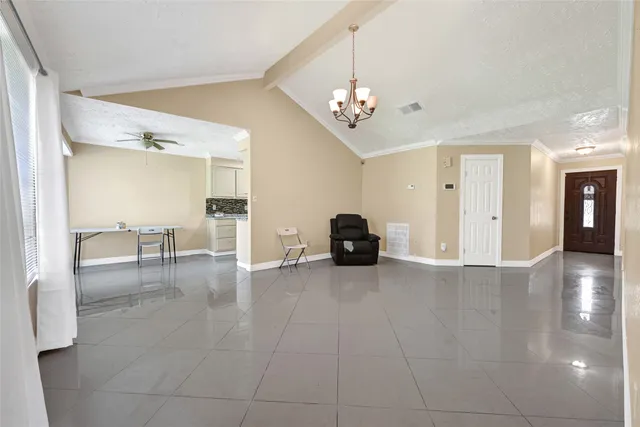 a view of an empty room with wooden floor and a ceiling fan