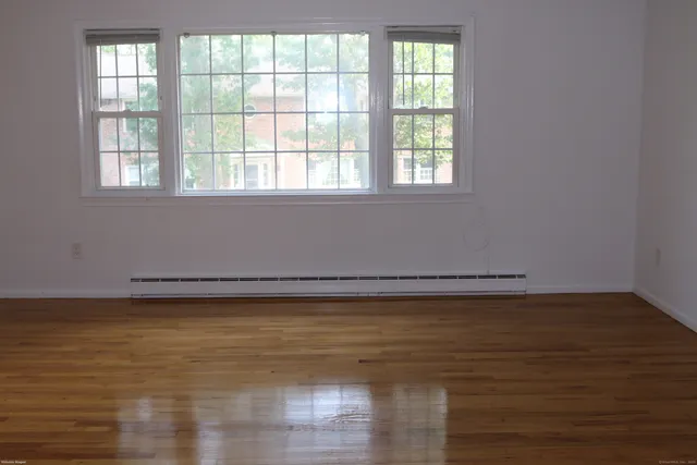 a view of a room with wooden floor and a window