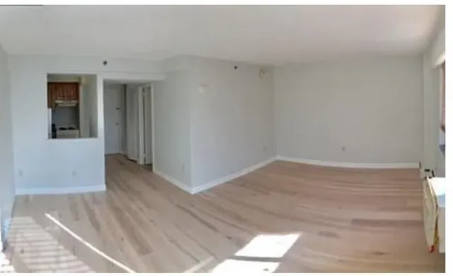a view of a room with wooden floor and entryway