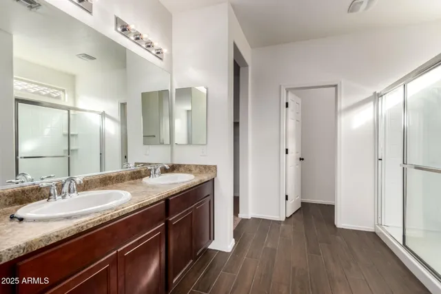 a bathroom with a granite countertop sink a mirror and a shower
