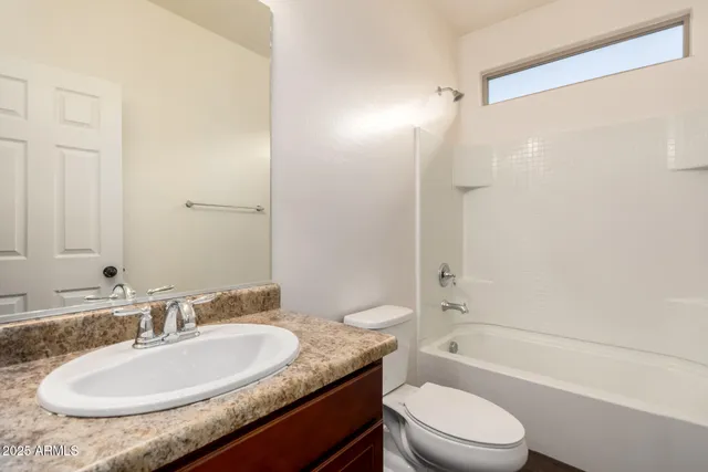 a bathroom with a granite countertop sink toilet mirror and shower