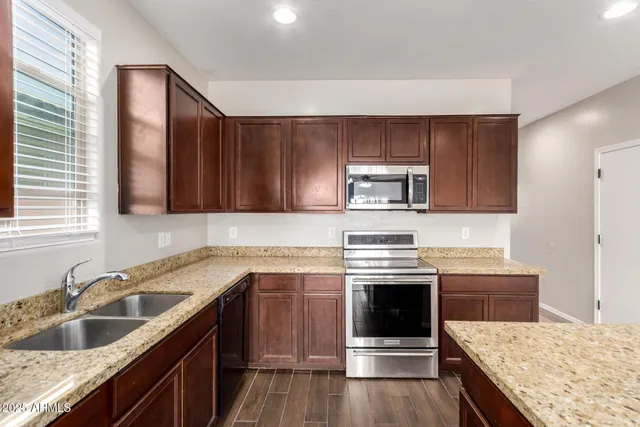 a kitchen with granite countertop a sink stove and cabinets