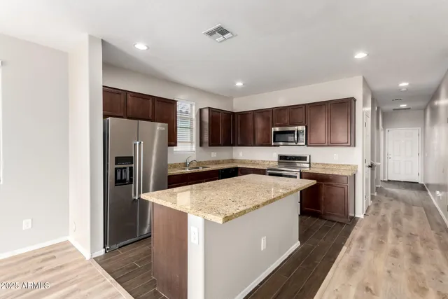 a kitchen with a sink a counter top space stainless steel appliances and cabinets