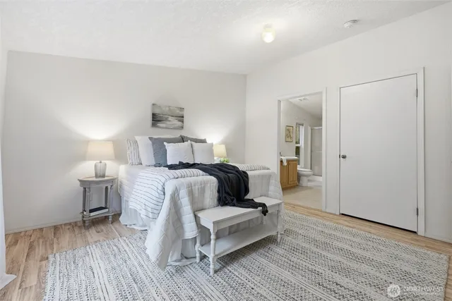 a bedroom with a bed and wooden floor