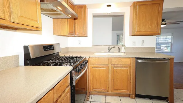 a kitchen with granite countertop a sink a stove and cabinets