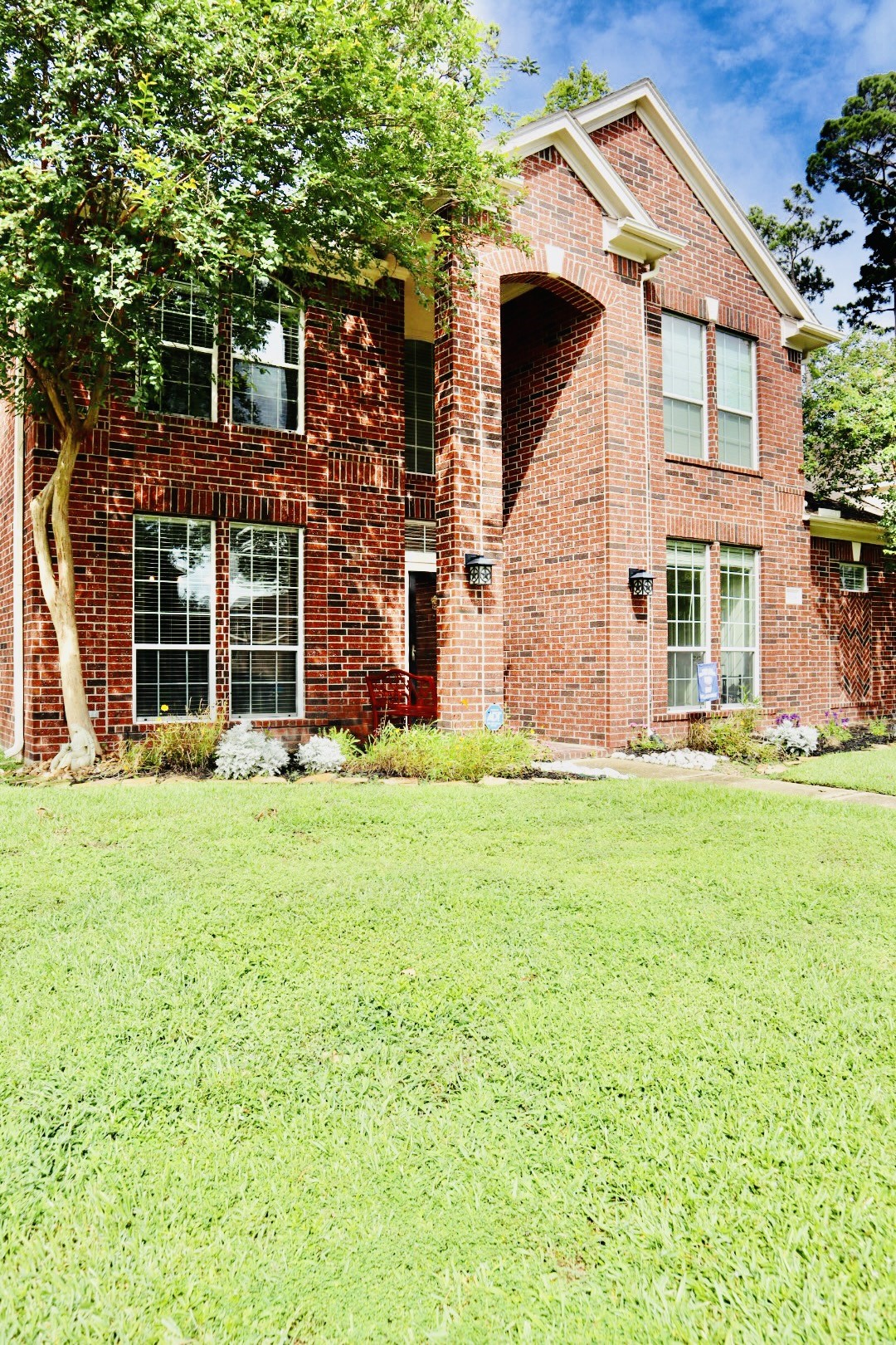 19114 Emory Trail Spring, TX 77388 - Photo 3 of 32 This is a charming two-story brick home with large windows, a well-maintained lawn, and mature trees, offering great curb appeal.