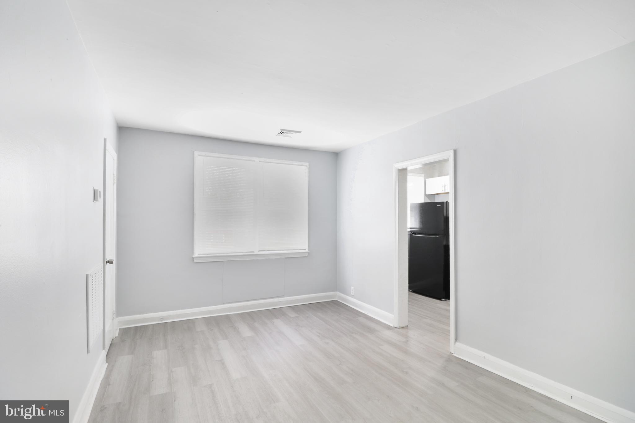 6151 Chinquapin Parkway Baltimore, MD 21239 - Photo 11 of 22 an empty room with wooden floor and windows