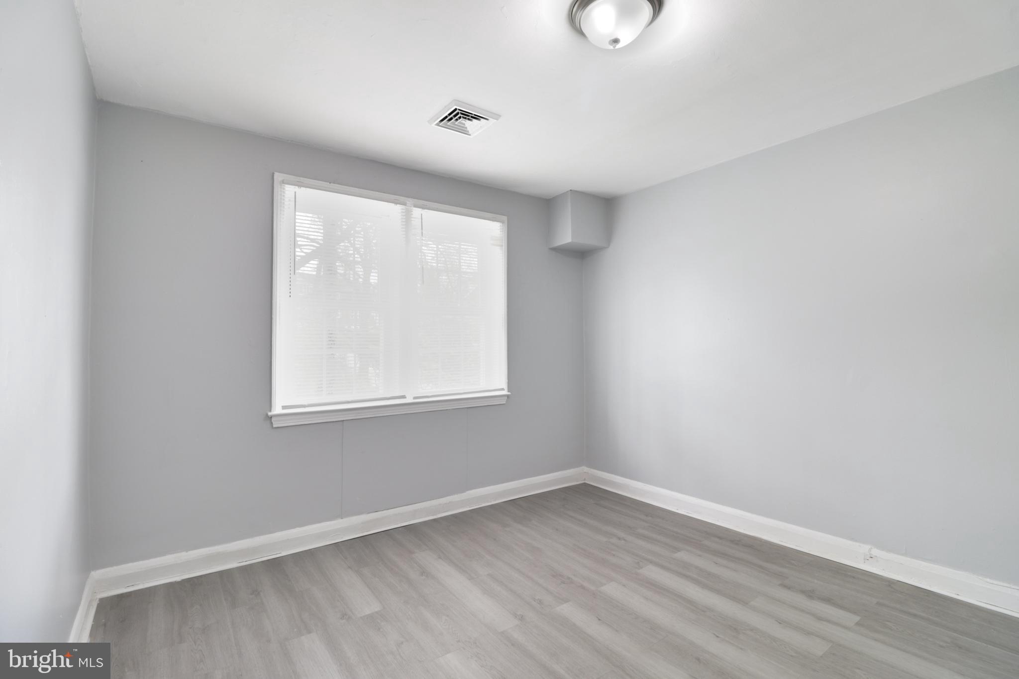 6151 Chinquapin Parkway Baltimore, MD 21239 - Photo 15 of 22 an empty room with wooden floor and windows