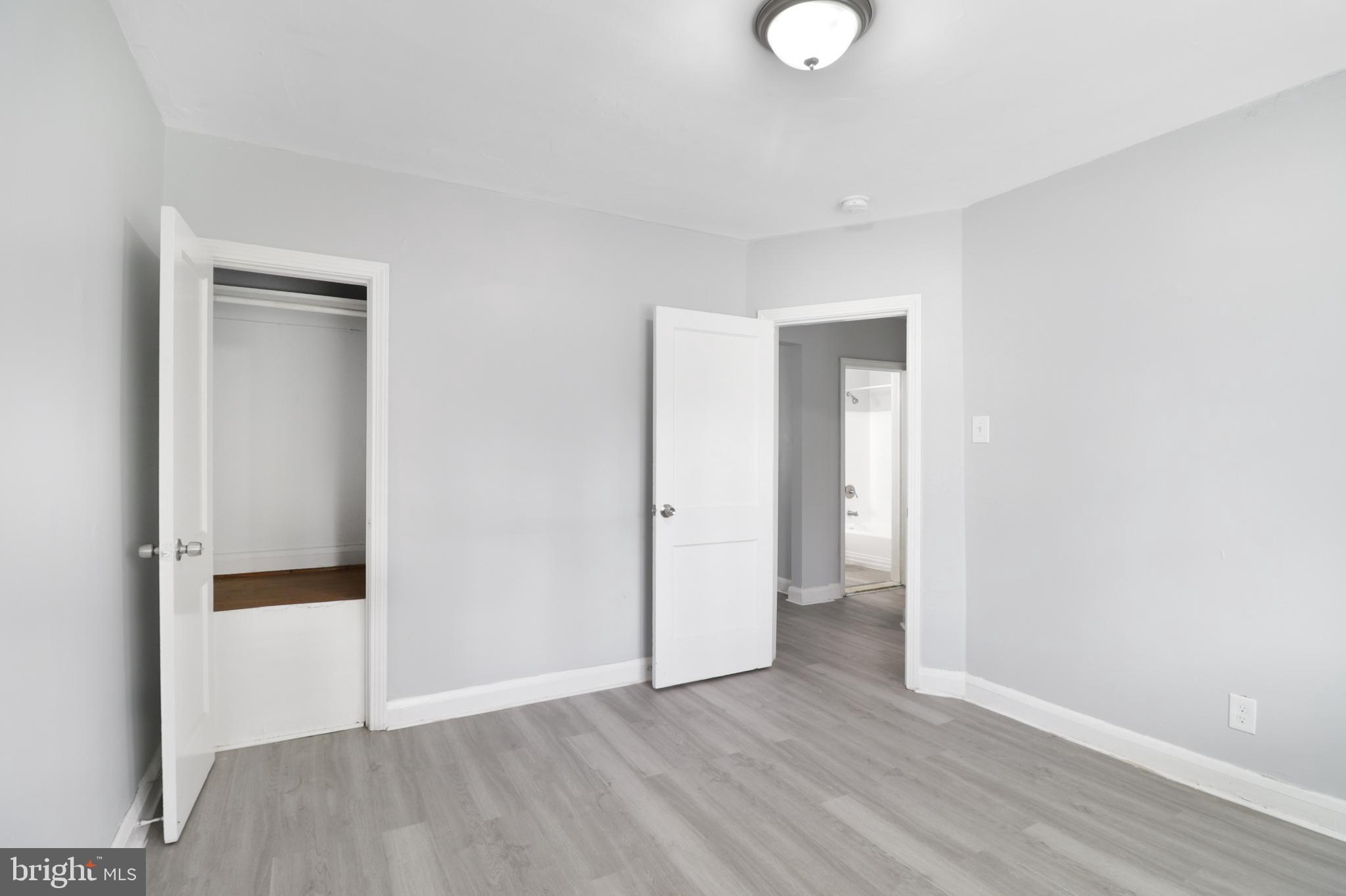 6151 Chinquapin Parkway Baltimore, MD 21239 - Photo 16 of 22 a view of an empty room with wooden floor and closet