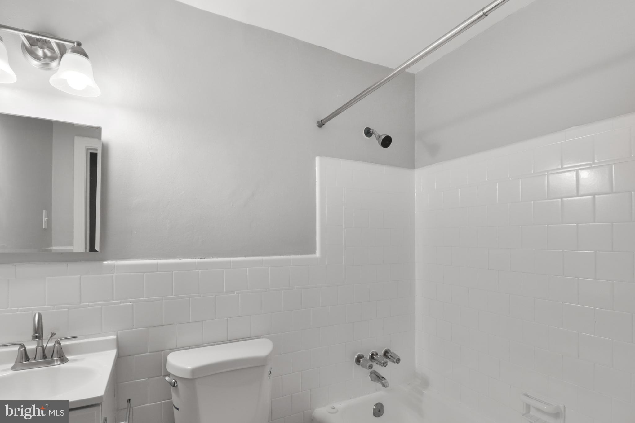 6151 Chinquapin Parkway Baltimore, MD 21239 - Photo 17 of 22 a bathroom with a sink a toilet and shower