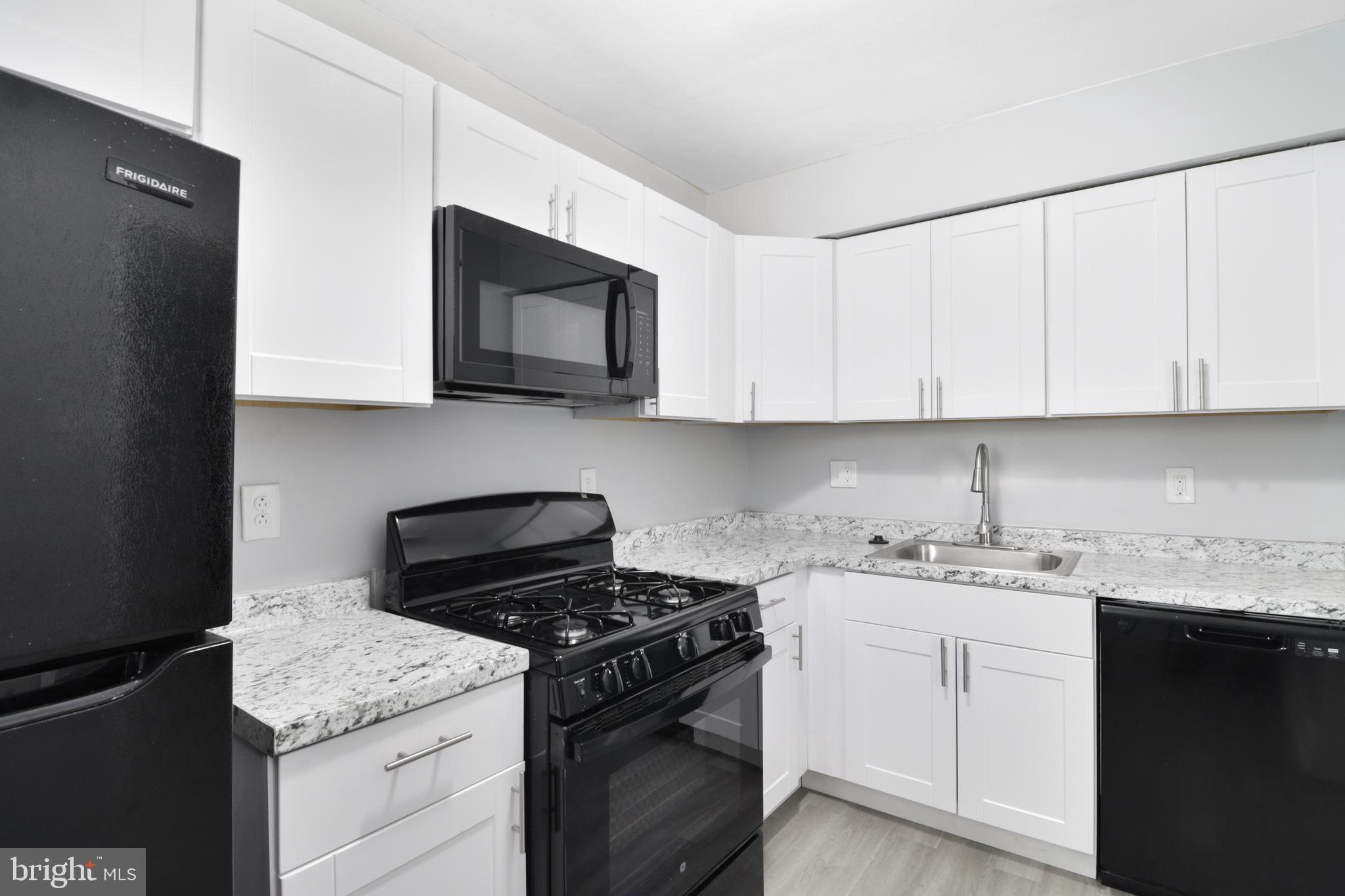 6151 Chinquapin Parkway Baltimore, MD 21239 - Photo 18 of 22 a kitchen with stainless steel appliances granite countertop white cabinets sink and dishwasher