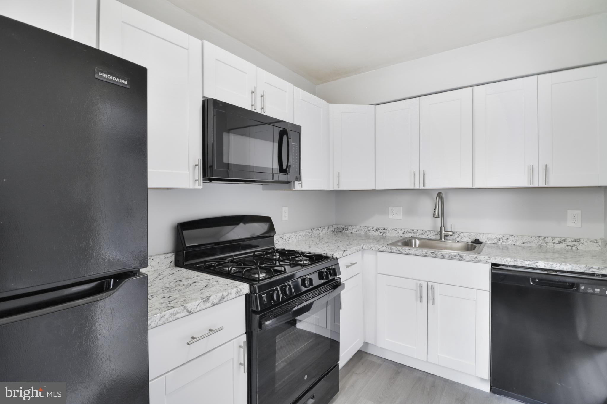 6151 Chinquapin Parkway Baltimore, MD 21239 - Photo 7 of 22 a kitchen with stainless steel appliances granite countertop a stove a sink and a microwave