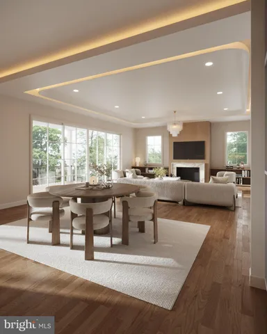 a living room with couches a coffee table and kitchen view with wooden floor