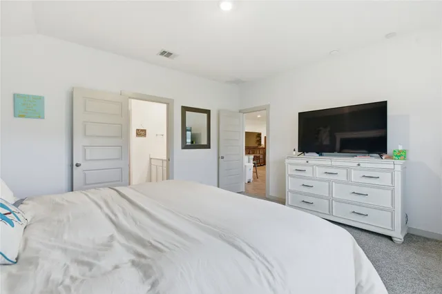 a bedroom with a bed and flat screen tv