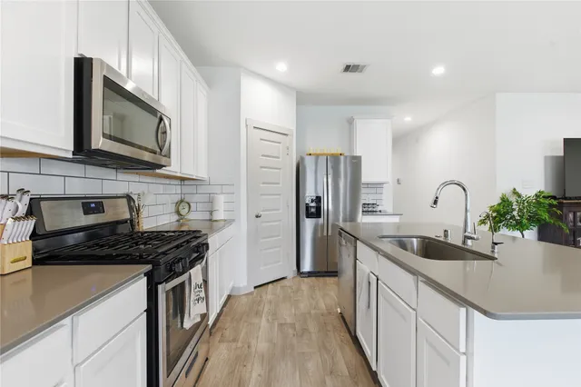 a kitchen with stainless steel appliances a sink stove and refrigerator