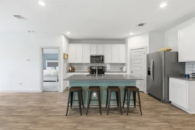 a kitchen with refrigerator cabinets and wooden floor