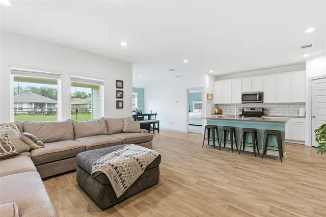 a living room with furniture and kitchen view