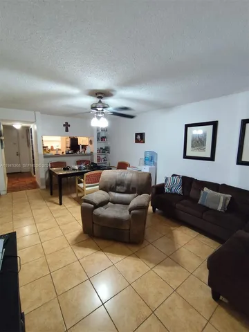 a living room with furniture and a dining table with projector