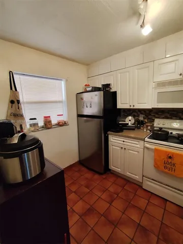 a kitchen with a sink a refrigerator and cabinets