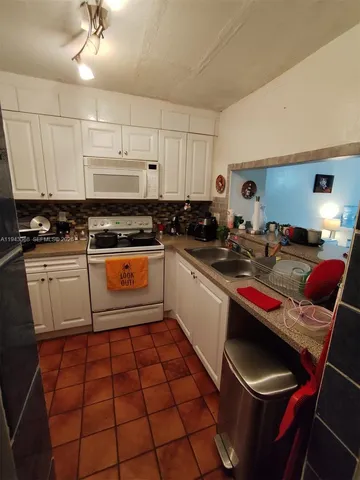 a kitchen with a sink a stove and cabinets