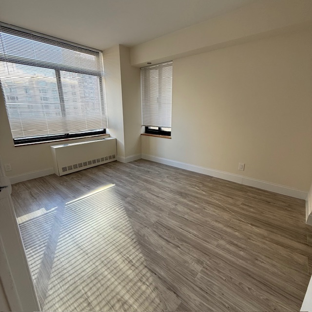 400 East 70th Street, Unit 907 Manhattan, NY 10021 - Photo 12 of 13 a view of an empty room with wooden floor and a window