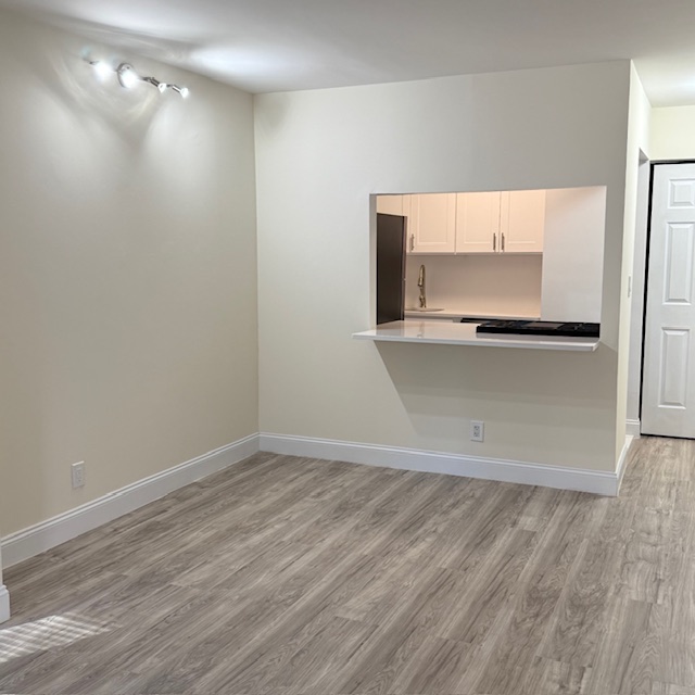 400 East 70th Street, Unit 907 Manhattan, NY 10021 - Photo 5 of 13 a view of a kitchen with a fridge and wooden floor