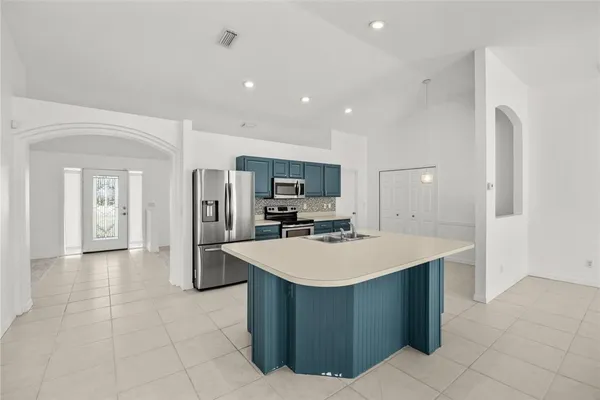 a large kitchen with stainless steel appliances a large counter top and a stove