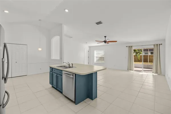 an open kitchen with a sink and a stove top oven