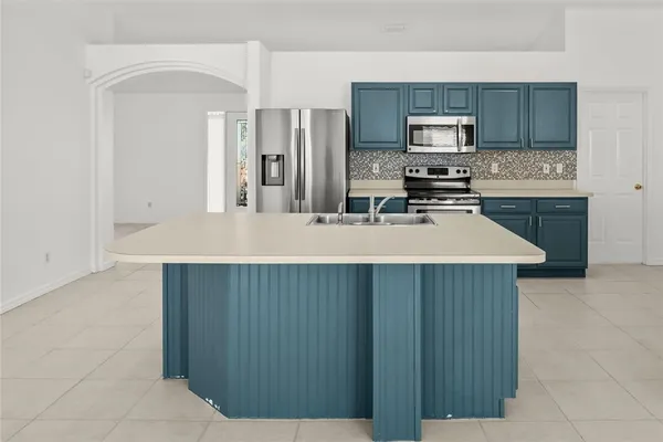 a kitchen with kitchen island a sink stainless steel appliances and cabinets