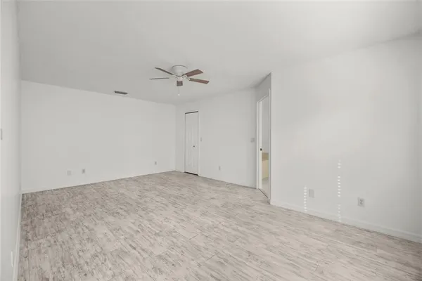 a view of an empty room with a chandelier fan