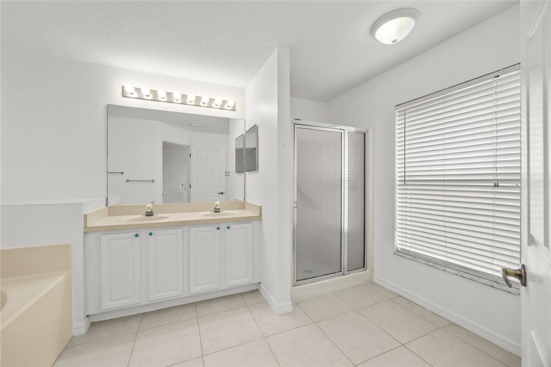 742 46th Square Vero Beach, FL 32968 - Photo 21 of 36 a spacious bathroom with a double vanity sink and a mirror
