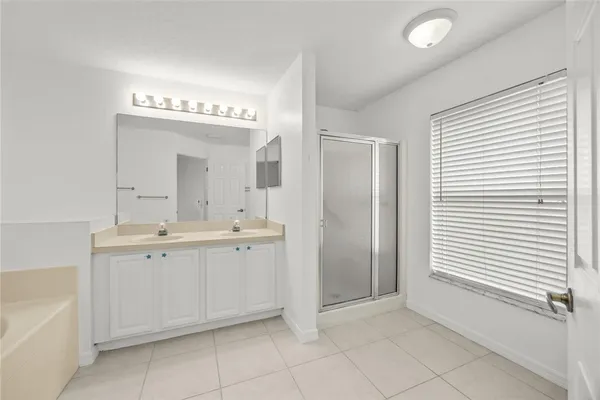 a spacious bathroom with a double vanity sink and a mirror