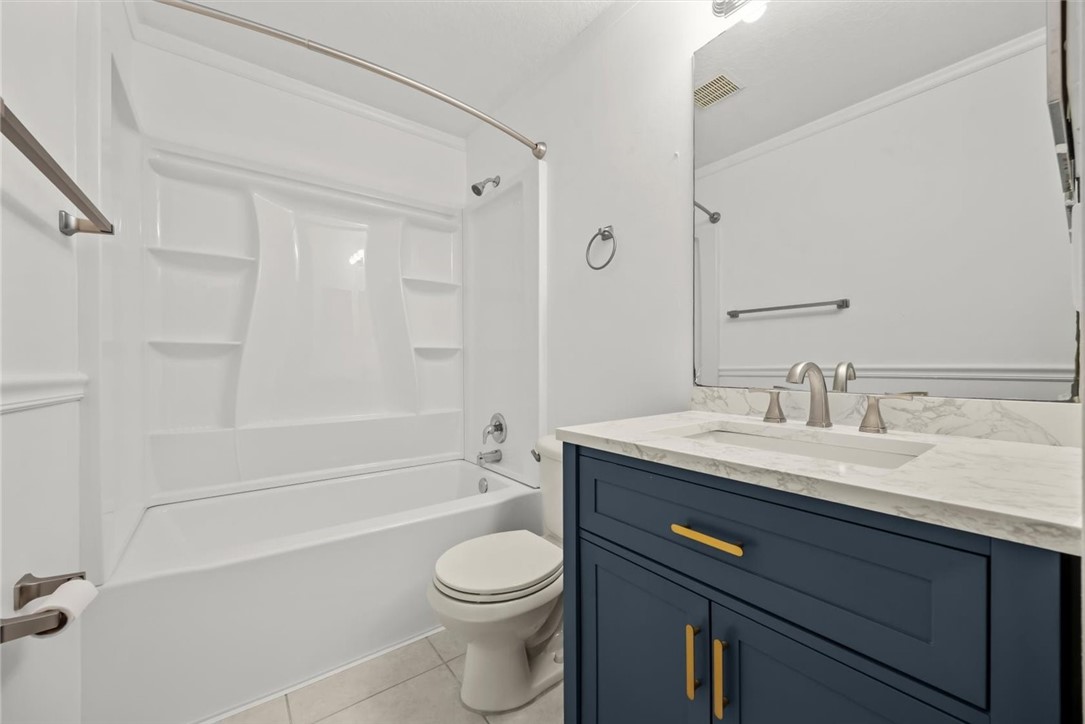 742 46th Square Vero Beach, FL 32968 - Photo 26 of 36 a bathroom with a granite countertop sink a toilet a mirror and shower