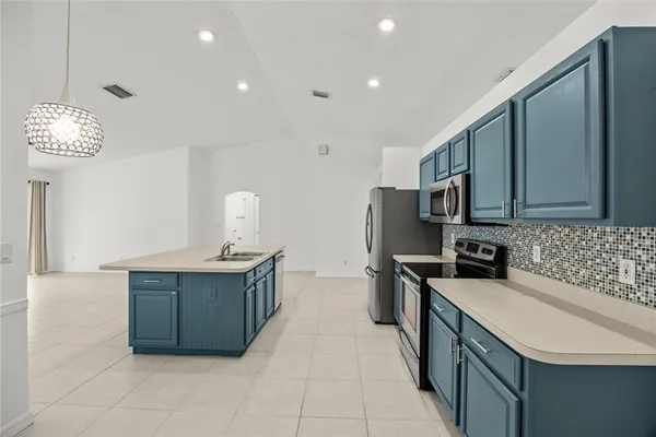 a kitchen with stainless steel appliances a sink stove and cabinets