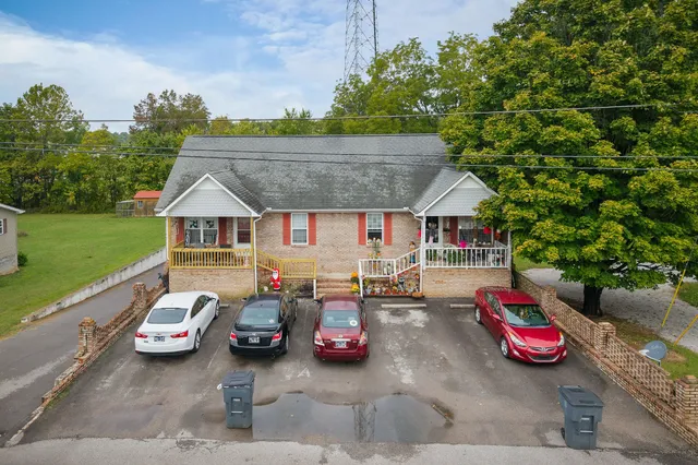 a front view of a house with cars parked