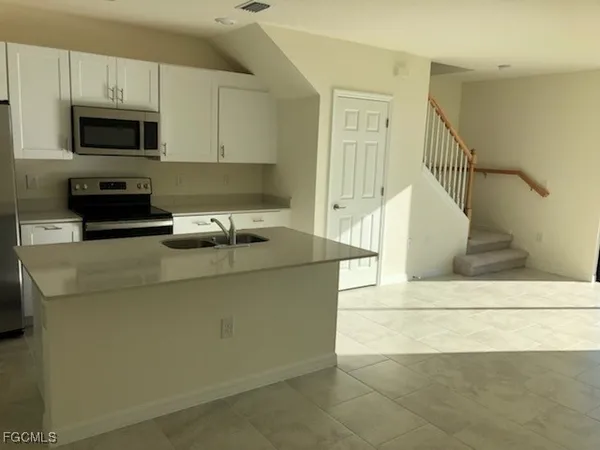 a kitchen with a sink a microwave and cabinets