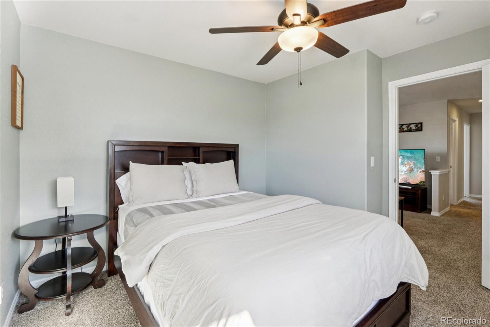 3120 Redhaven Way Highlands Ranch, CO 80126 - Photo 16 of 50 a bedroom with a bed and a chandelier