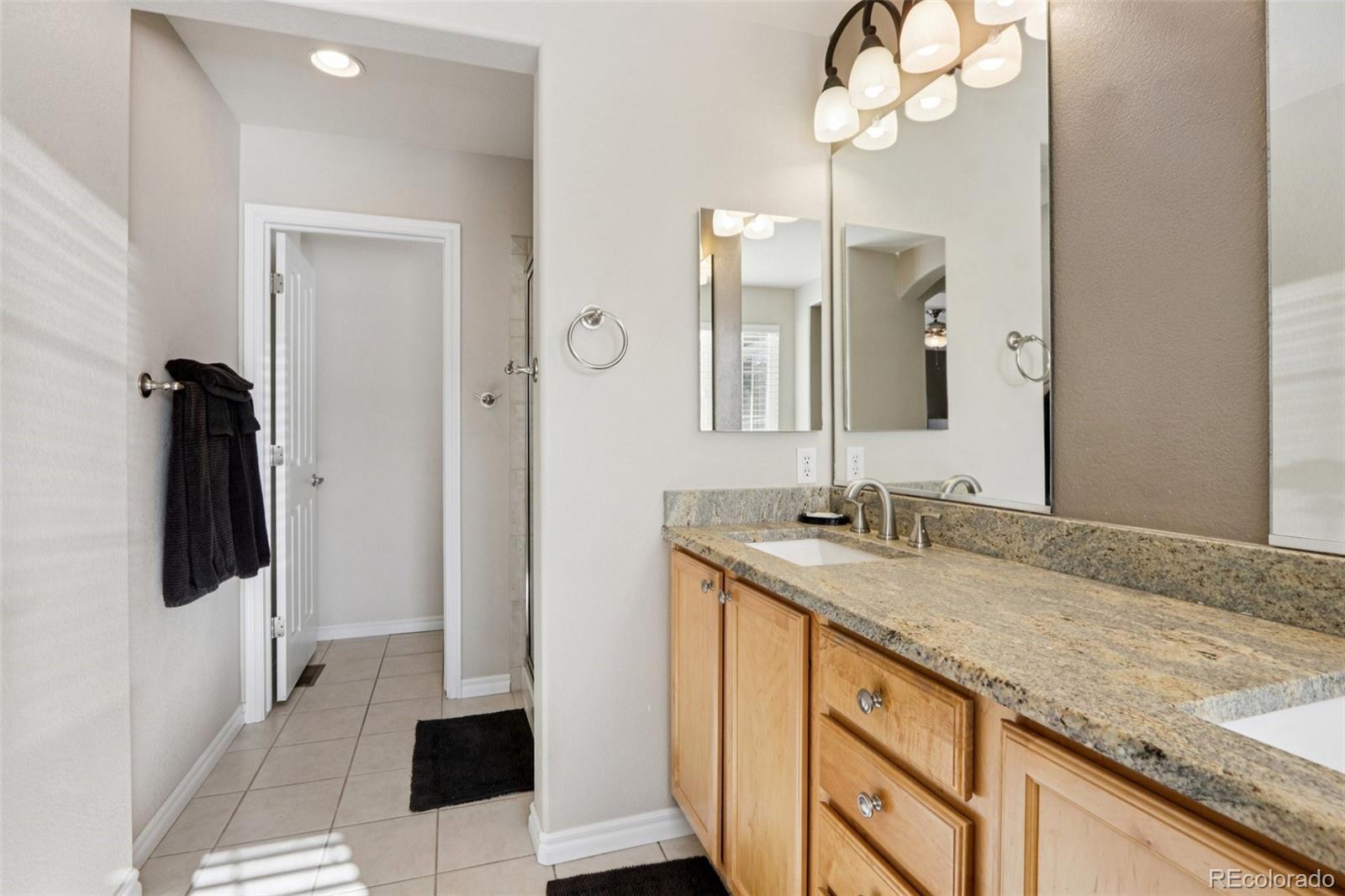 3120 Redhaven Way Highlands Ranch, CO 80126 - Photo 33 of 50 a bathroom with a granite countertop sink a mirror and vanity