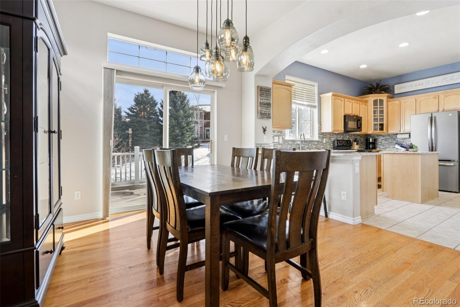 3120 Redhaven Way Highlands Ranch, CO 80126 - Photo 6 of 50 a view of a dining room with furniture large windows a chandelier and wooden floor