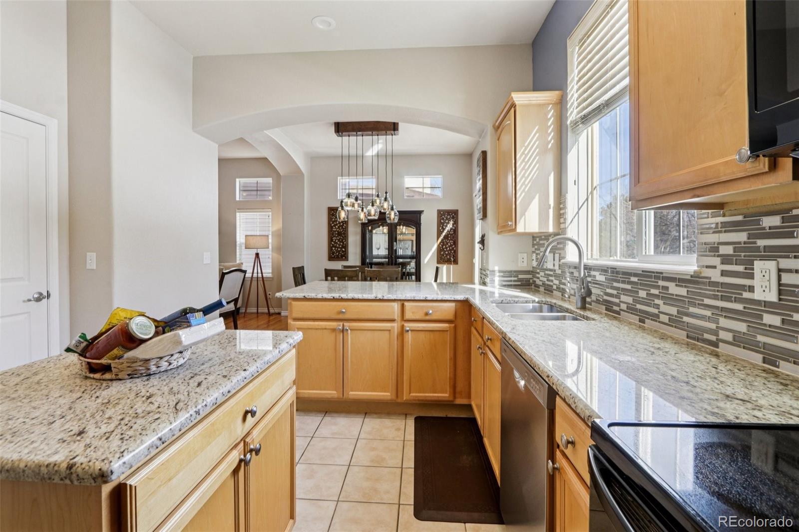 3120 Redhaven Way Highlands Ranch, CO 80126 - Photo 10 of 50 a large kitchen with granite countertop a sink and a stove next to a large window