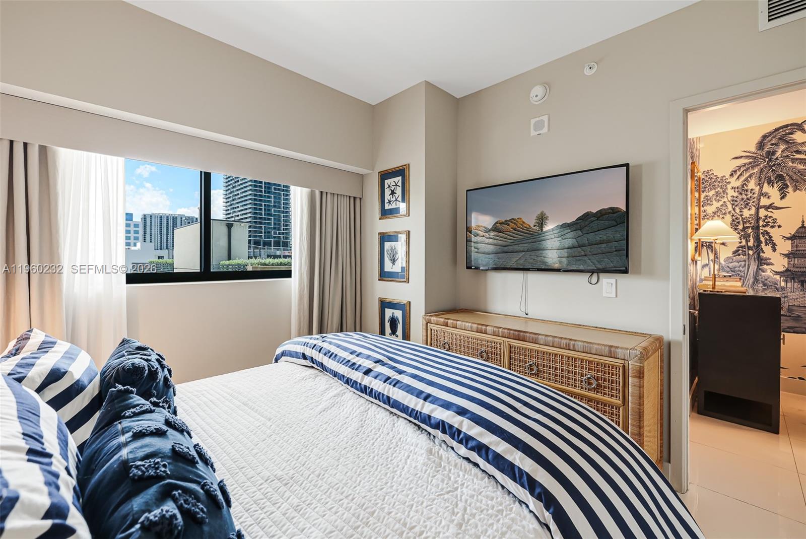 460 Northeast 28th Street, Unit 704 Miami, FL 33137 - Photo 35 of 53 a bedroom with a bed and a flat screen tv