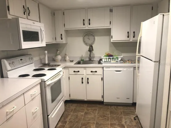 a kitchen with stainless steel appliances granite countertop a stove a refrigerator and a microwave