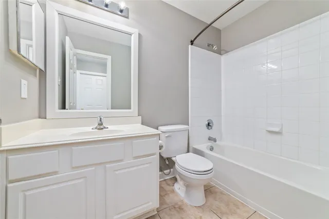 a bathroom with a toilet sink a mirror and shower