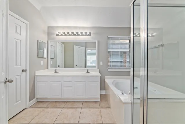 a spacious bathroom with a tub shower and sink