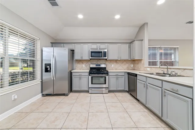a kitchen with stainless steel appliances granite countertop a stove a sink and a refrigerator