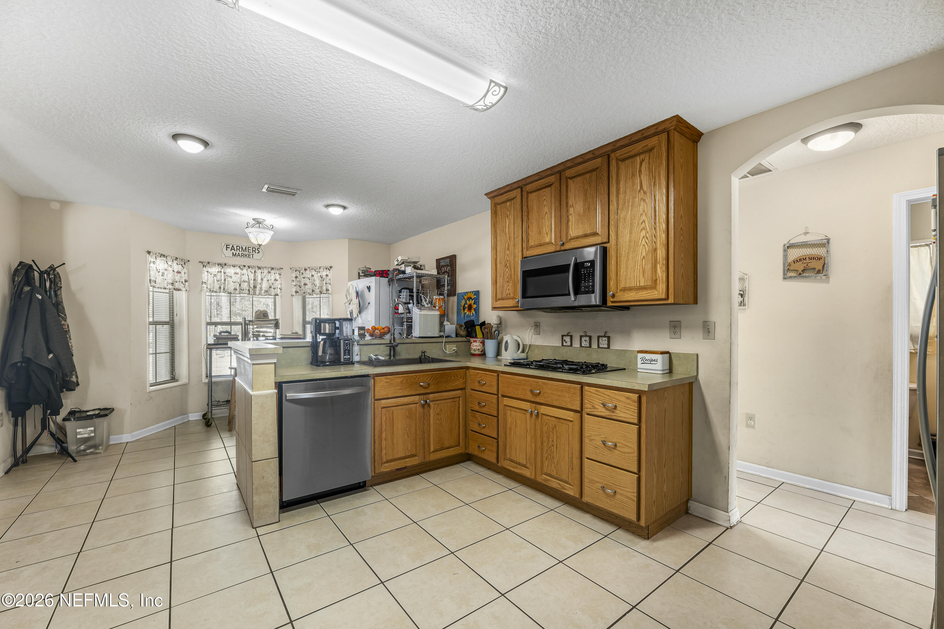 1725 Davidson Farm Road Jacksonville, FL 32218 - Photo 24 of 55 a kitchen with stainless steel appliances granite countertop a refrigerator and a stove top oven